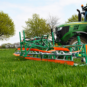 A combcutting implement removing broadleaf plants from a grass crop.
