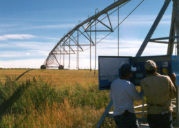 two men working on center pivot irrigation system