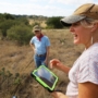 three people in a pasture with a tablet
