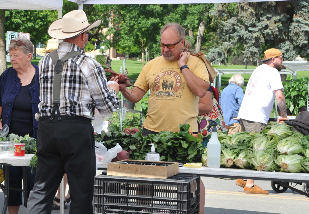 A man purchases fresh produce at the Helena, Montana farmers market.