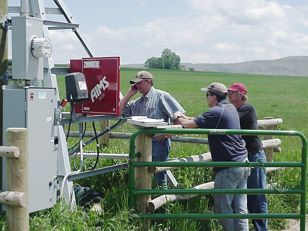 Men working on the electrical box of a pump in the field