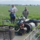 men working on an irrigation pump in a field