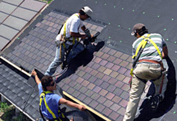 roofers installing PV shingles on a roof