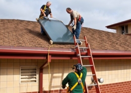 Crew Installing a flat plate solar water heating collector.