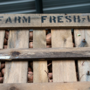 Wooden crate of sweet potatoes labeled "Farm Fresh"