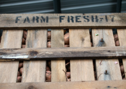 Wooden crate of sweet potatoes labeled "Farm Fresh"
