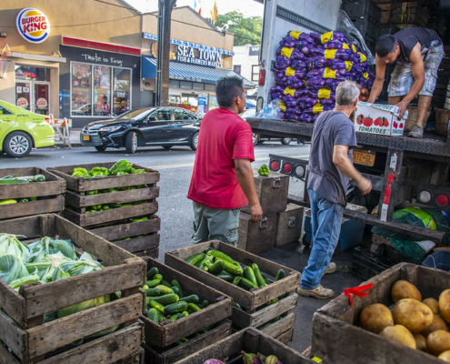 Men unloading boxes of produce from a truck