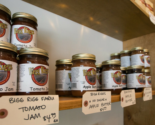 jars of jam on a shelf with signs