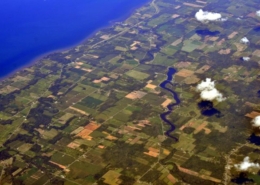 aerial photo of Lake Ontario shoreline in New York, showing water, clouds, and land parcels