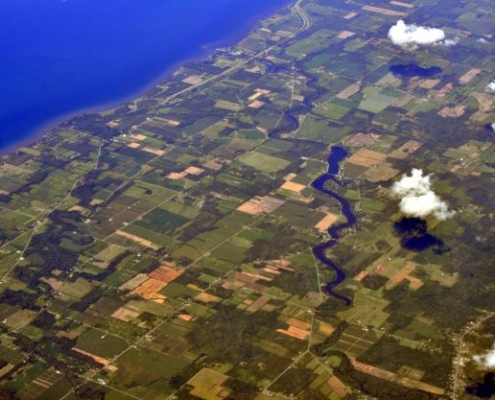 aerial photo of Lake Ontario shoreline in New York, showing water, clouds, and land parcels