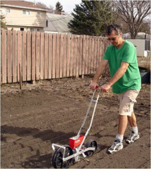 El agricultor Wally Satzewich de Wally's Urban MarketGarden en Saskatoon, Saskatchewan, usando una sembradora Earthway
