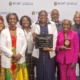 group of people facing camera holding award plaques