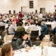 a room full of people sitting at round tables