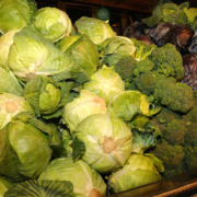 green cabbage, broccoli, and red cabbage piled in a display