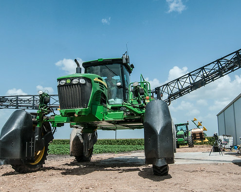 parked crop spraying equipment against blue sky background