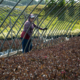 Person standing between two uncovered hoophouse frames amid planted crop.