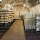 racks of round cheeses in a cheese cave