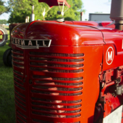 close photo of the front of a historic red Farmall tractor.