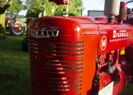 close photo of the front of a historic red Farmall tractor.