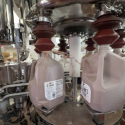 plastic bottles being filled with chocolate milk by a machine