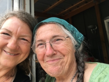 Two women taking a selfie, looking at the camera smiling. 