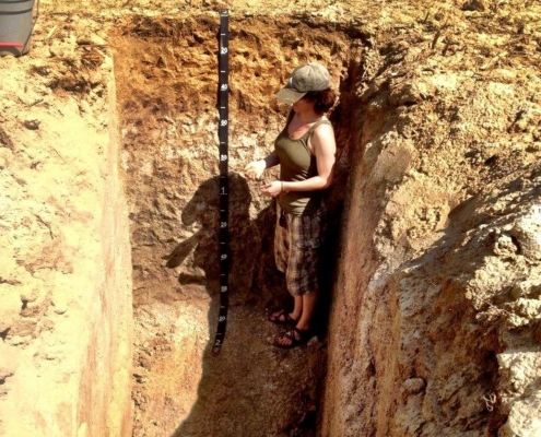 Dr. Faye Smith Measuring Soil Health in a soil pit.