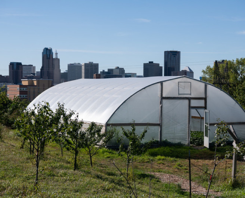 high tunnel in front of urban skyline under blue sky
