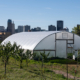 high tunnel in front of urban skyline under blue sky