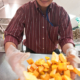 person stirs squash cubes with a gloved hand