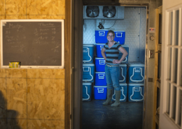 looking through a doorway at a person standing in front of coolers in a produce cooling room
