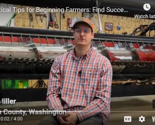 A seated person in front of farm equipment
