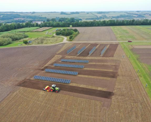 aerial view of solar panels on a plowed farm field