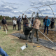 a group of people assembling the frame of a high tunnel