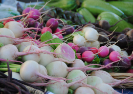 stacks of vegetables on display at market