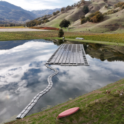 solar array floating on a pond with hills in background