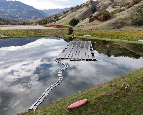 solar array floating on a pond with hills in background