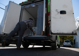 A person removing boxes from an insulated box truck