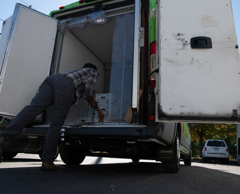 A person removing boxes from an insulated box truck