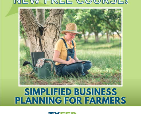 A person sits on the ground under a tree, writing on a clipboard.